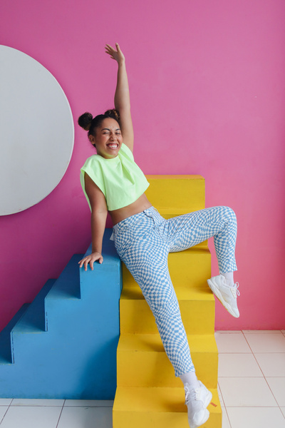 Happy Woman in Colorful Outfit Sitting on Steps