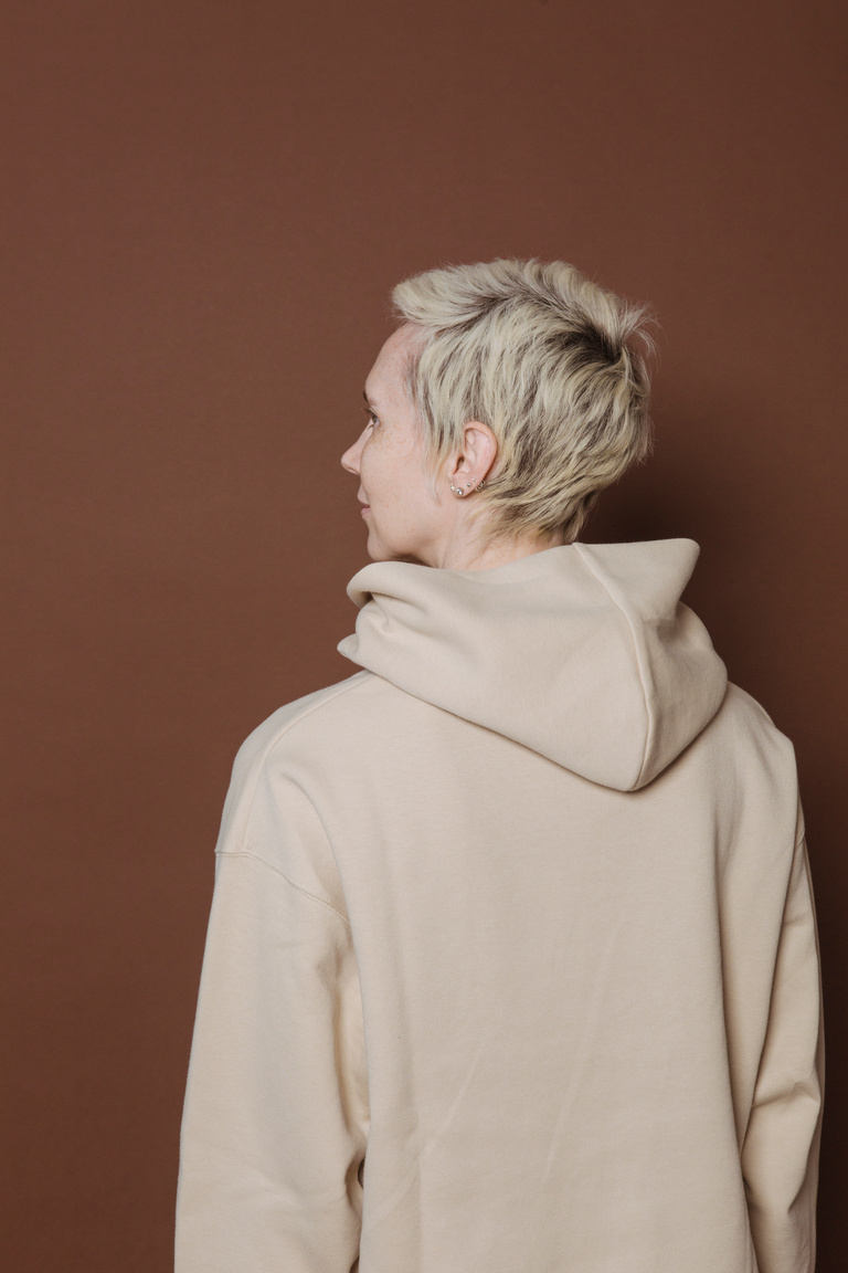 Serious young woman in trendy hoodie in studio